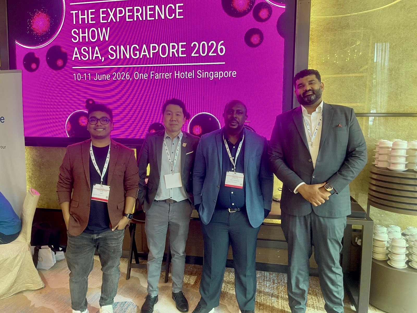 Group photo in front of The Experience Show Asia Singapore 2026 screen at One Farrer Hotel